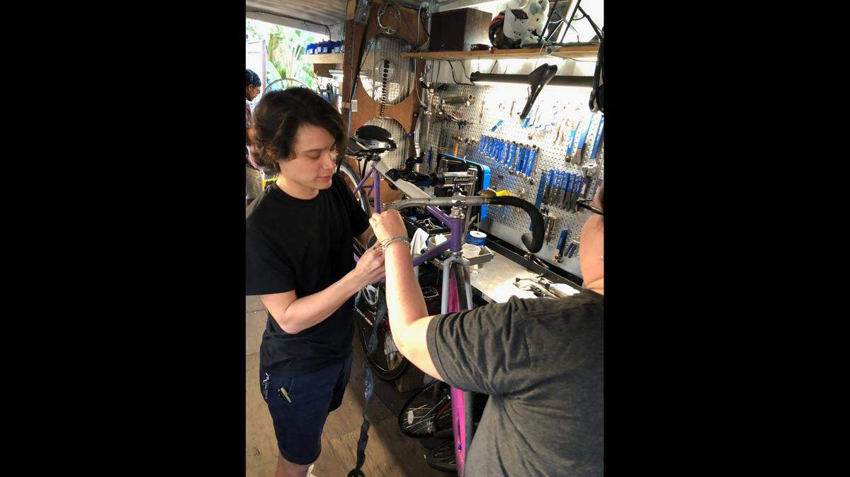 Magic City Bicycle Collective volunteer Marcelo Araica, left, installs bar tape on a bike for a customer. The collective is a nonprofit that accepts donations of new and used bicycles. Some bikes are sold to pay bills, and the rest are donated to those in need.