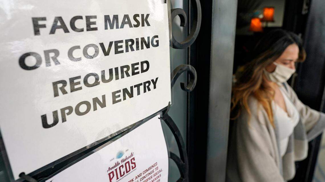 A sign asking customers to wear a face covering is displayed at the entrance to Picos restaurant Wednesday, March 10, 2021, in Houston.