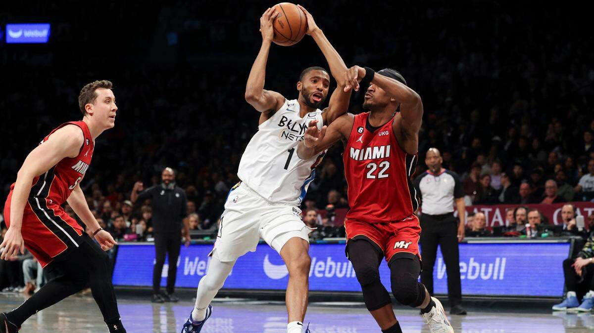 Brooklyn Nets forward Mikal Bridges (1) drives against Miami Heat forward Jimmy Butler (22) as Miami Heat forward Duncan Robinson watches during the second half of an NBA basketball game Wednesday, Feb. 15, 2023, in New York.