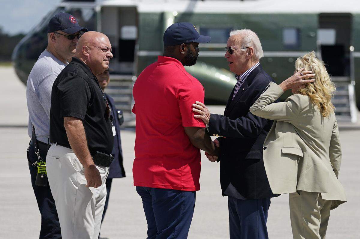 President Joe Biden shakes hands with Rep. Byron Donalds, R-Fla., center, as he and first lady Jill Biden are greeted after arriving at Southwest Florida International Airport to visit areas impacted by Hurricane Ian, Wednesday, Oct. 5, 2022, in Fort Myers, Florida. Lee County Chairman Cecil Pendergrass, second from left, looks on.