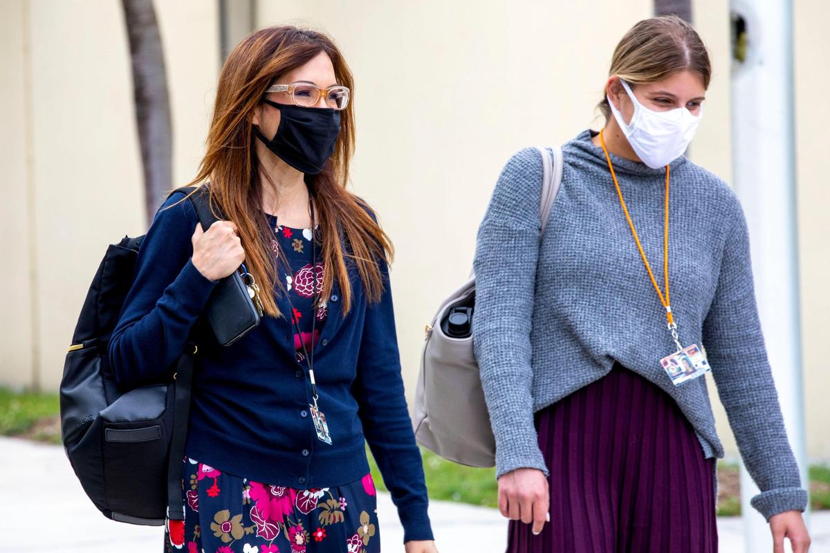Booker T. Washington Senior High School teachers Maria Capps, left, and Jordan Schwartz, right, walk across campus after dismissal in Miami, Florida, on Monday, Jan. 3, 2022. Capps teaches journalism and English while Schwartz teaches English and creative writing.
