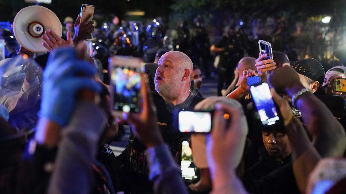 Protesters film police on May 31, 2020 in Atlanta, Georgia.