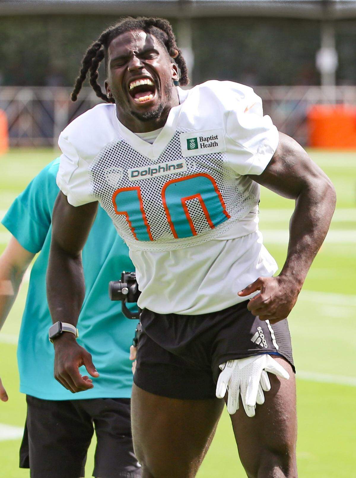 Miami Dolphins wide receiver Tyreek Hill (10) motivates the fans as the team rushes the field for practice at Baptist Health Training Complex in Miami Gardens on Saturday, July 30, 2022.