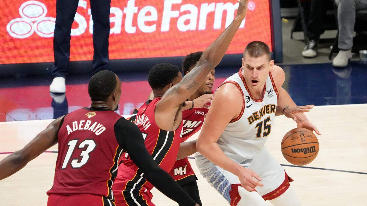 El centro de los Nuggets Nikola Jokic (15) dribla el balón ante la marca de Haywood Highsmith (24) y Kyle Lowry (atrás), del Heat de Miami, durante el segundo cuarto del Juego 5 de las Finales de la NBA, celebrado el 12 de junio de 2023 en el Ball Arena de Denver.
