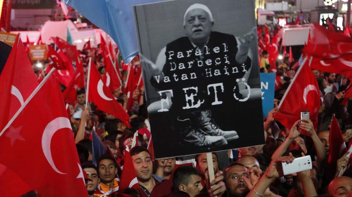 In 2016, pro-government supporters in Ankara wave Turkish flags and hold signs calling Fethullah Gülen, head of FETO, a traitor.