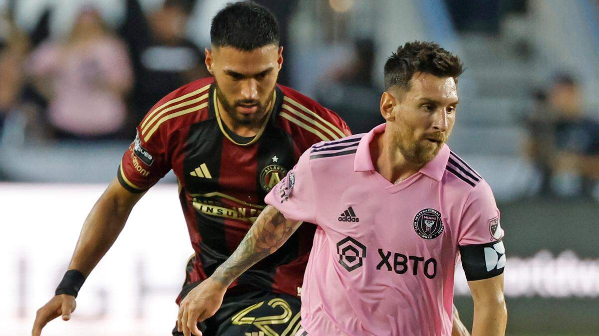 El delantero de Inter Miami Lionel Messi  controla el balón ante el defensa de Atlanta United Juan Purata, en la segunda mitad del  partido de la fase de grupos de la Leagues Cup, celebrado el 25 de julio de 2023 en el  estadio DRV PNK en Fort Lauderdale, Florida.
