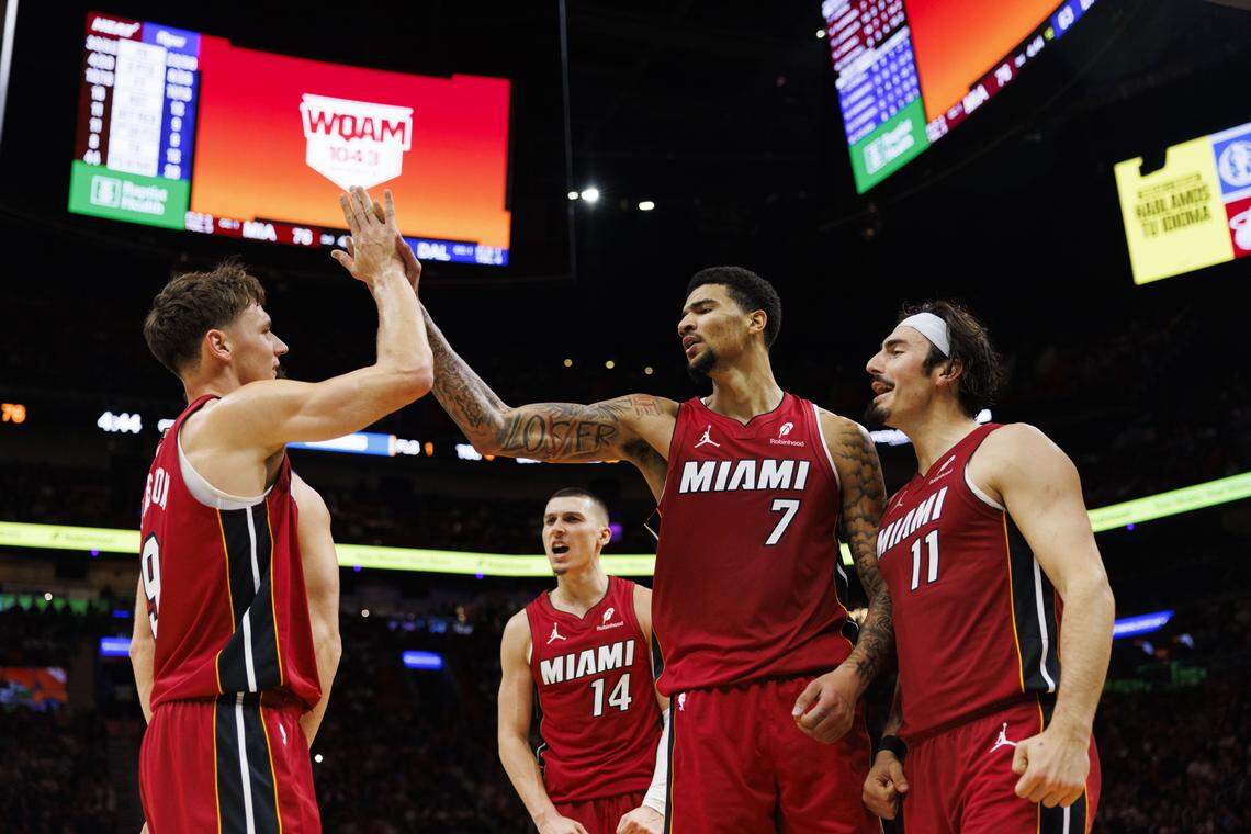 Miami Heat center Kel'el Ware (7) high-fives guard Pelle Larsson (9) with teammates Jaime Jaquez Jr. (11) and Tyler Herro (14) during the second half of a game against the Dallas Mavericks on Monday at Kaseya Center in Miami.