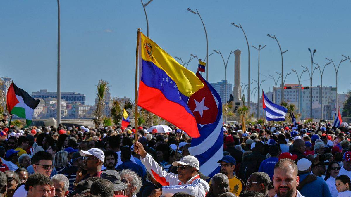 In Havana, Cubans hold a Venezuelan national flag with a Cuban one during a gathering in support of Venezuelan leader Nicolas Maduro after U.S. forces captured him.