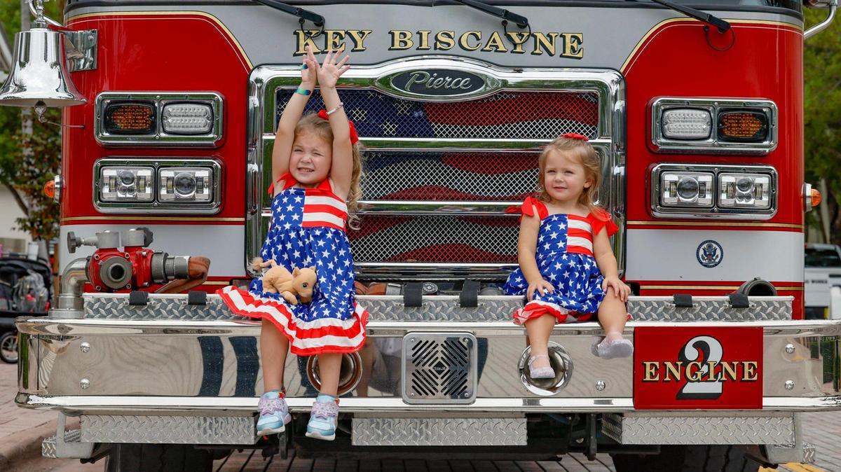 Sisters, Piper, 4, and Adeline Rosales, 2, visit with Key Biscayne Fire Rescue as residents, family and friends celebrate Independence Day at the 66th Annual Key Biscayne Fourth of July Parade on Key Biscayne, Florida on Friday, July 4, 2025.