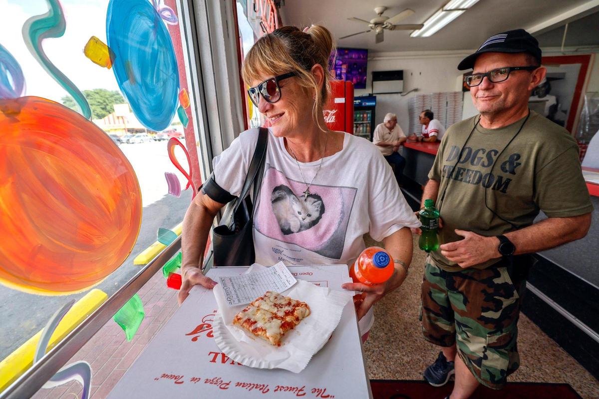 Customers Dawn Jackman-Brokaw and George Hubbard carry out their pizza order at Frankie’s Pizza on Bird Road.