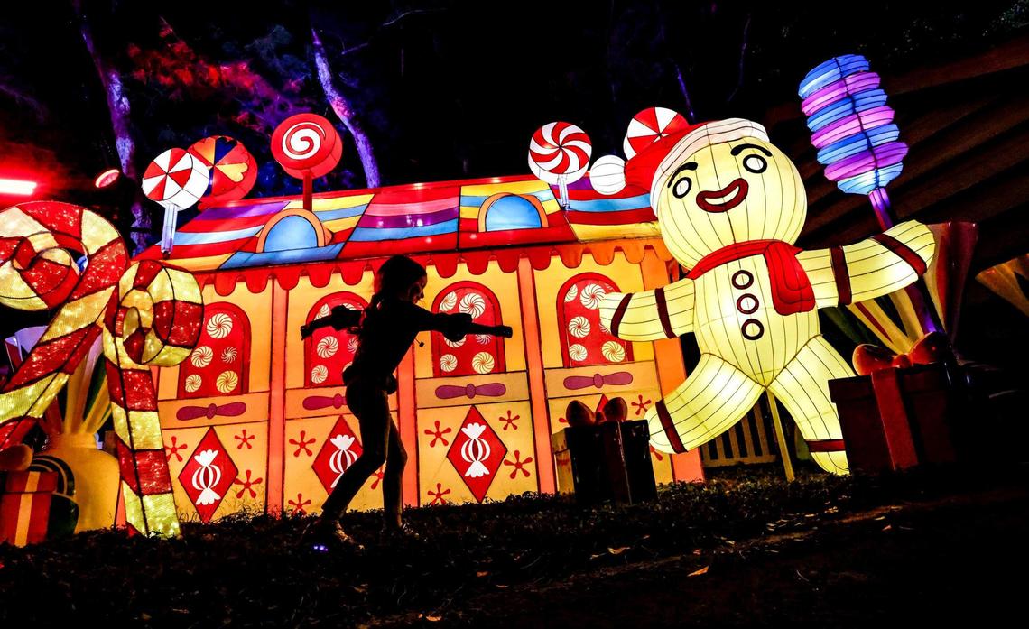 Sky Levine, 5, dances in front of the Gingerbread House display on SweetStreet along Tinsel Trail during Christmas Wonderland’s opening night at Tropical Park in Miami on Friday, November 17, 2023.
