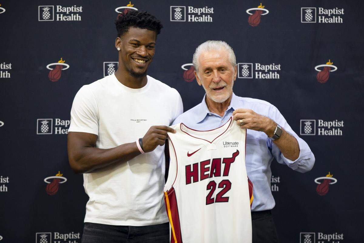 Miami Heat president Pat Riley presents Jimmy Butler with his Heat jersey during a press conference on the Heat’s practice court at then-AmericanAirlines Arena in Miami on September 27, 2019.
