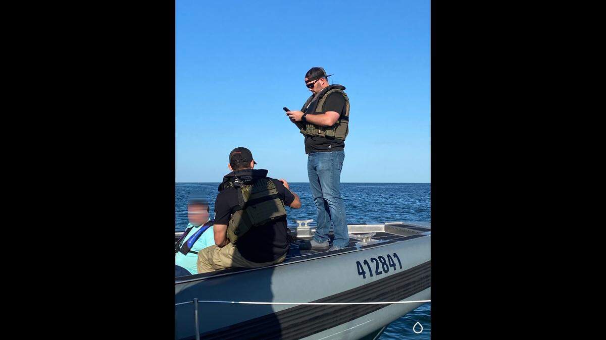 Lee County Sheriff Office deputies and U.S. Marshals arrest a man on a boat Sunday, May 16, 2021. He is wanted by police in Edmonds, Washington, on child rape and molestation charges.