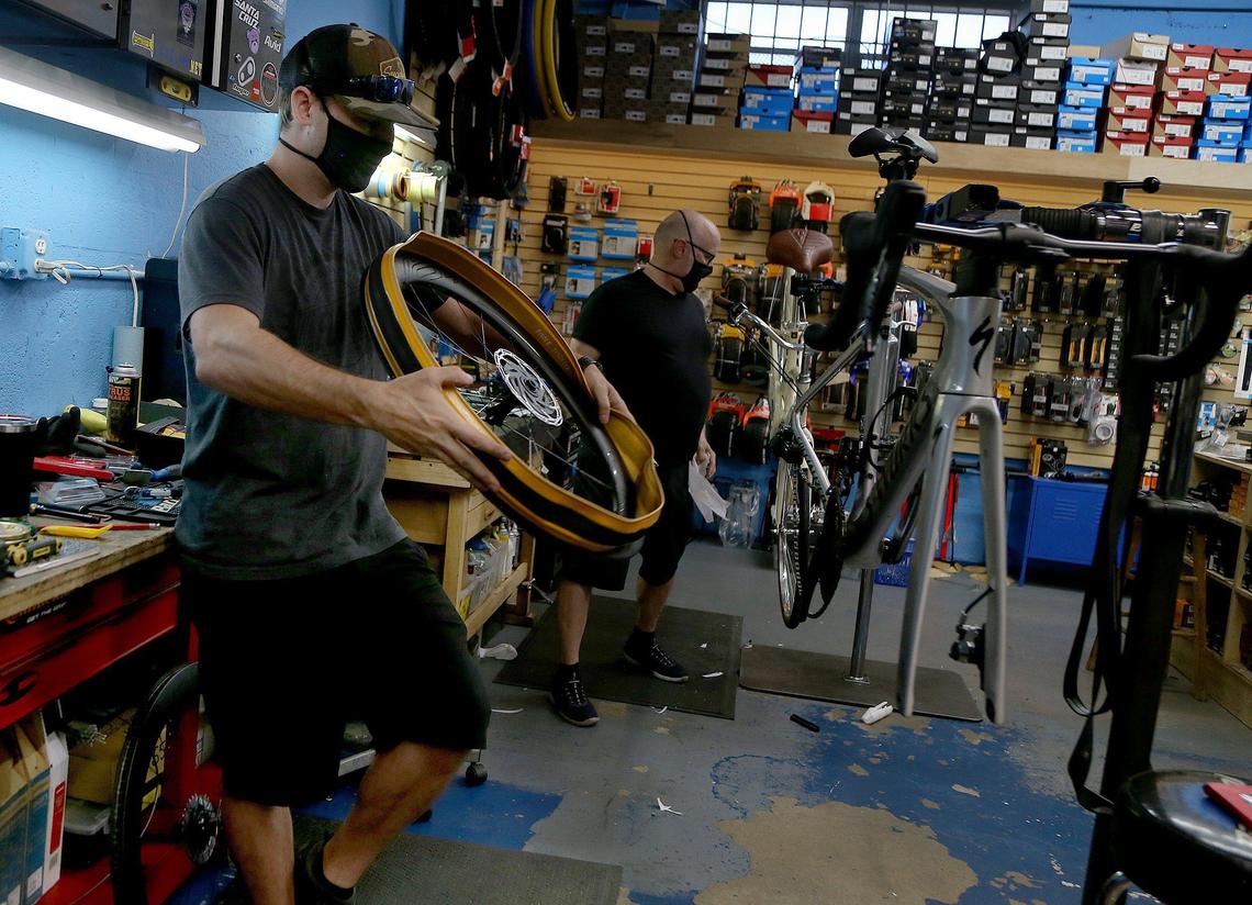 Mechanics Matt Walsh, left, and Calvin Neel assemble new bikes at Elite Cycling. The small shop was closed by the coronavirus pandemic, but is selling bikes for curbside pickup amid a spike in demand during the quarantine.