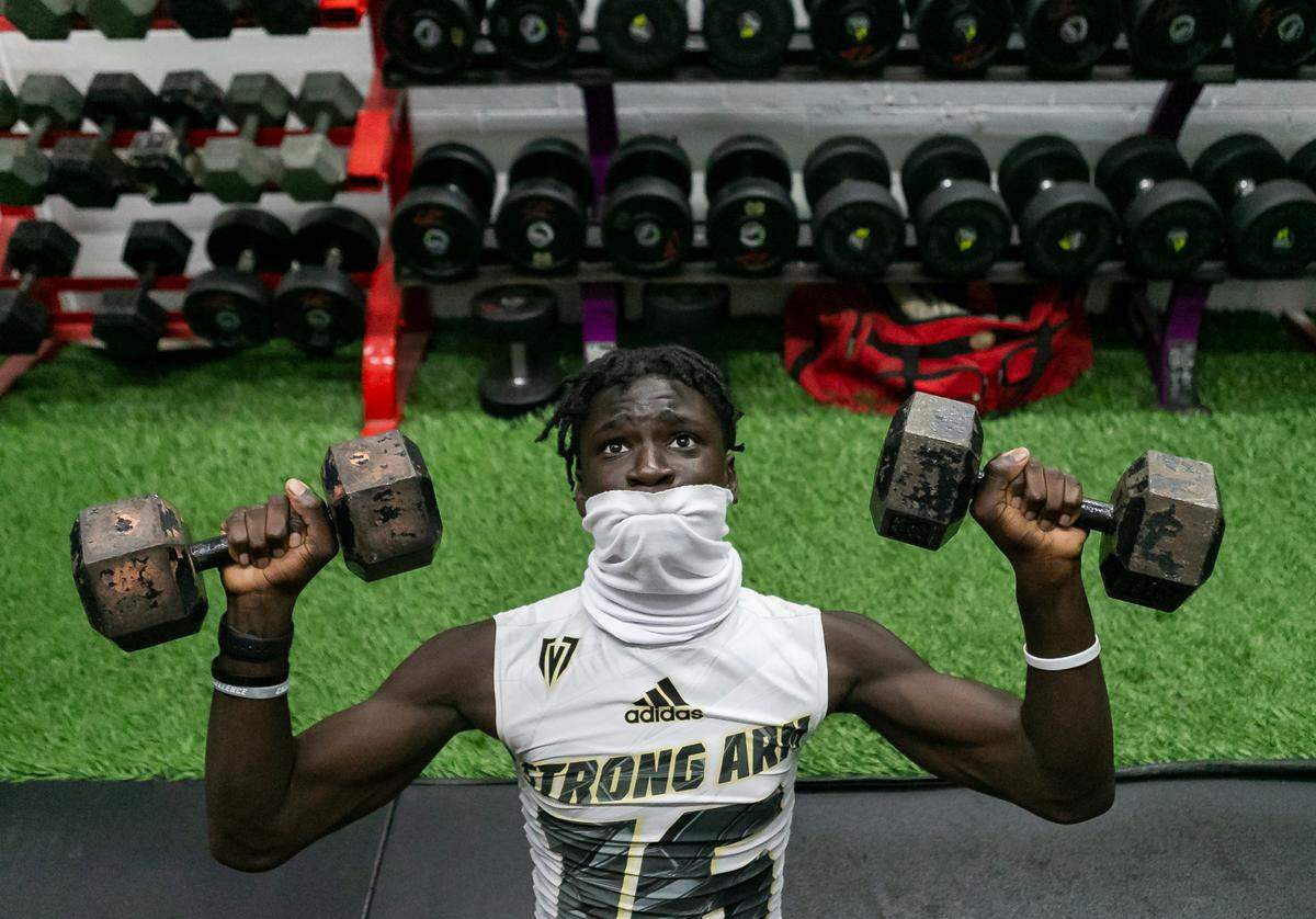 Monsignor Edward Pace wide receiver Za’ron Collins lifts weights before the start of a preseason practice at their school’s gym in Miami Gardens, Florida on Monday, August 2, 2021.