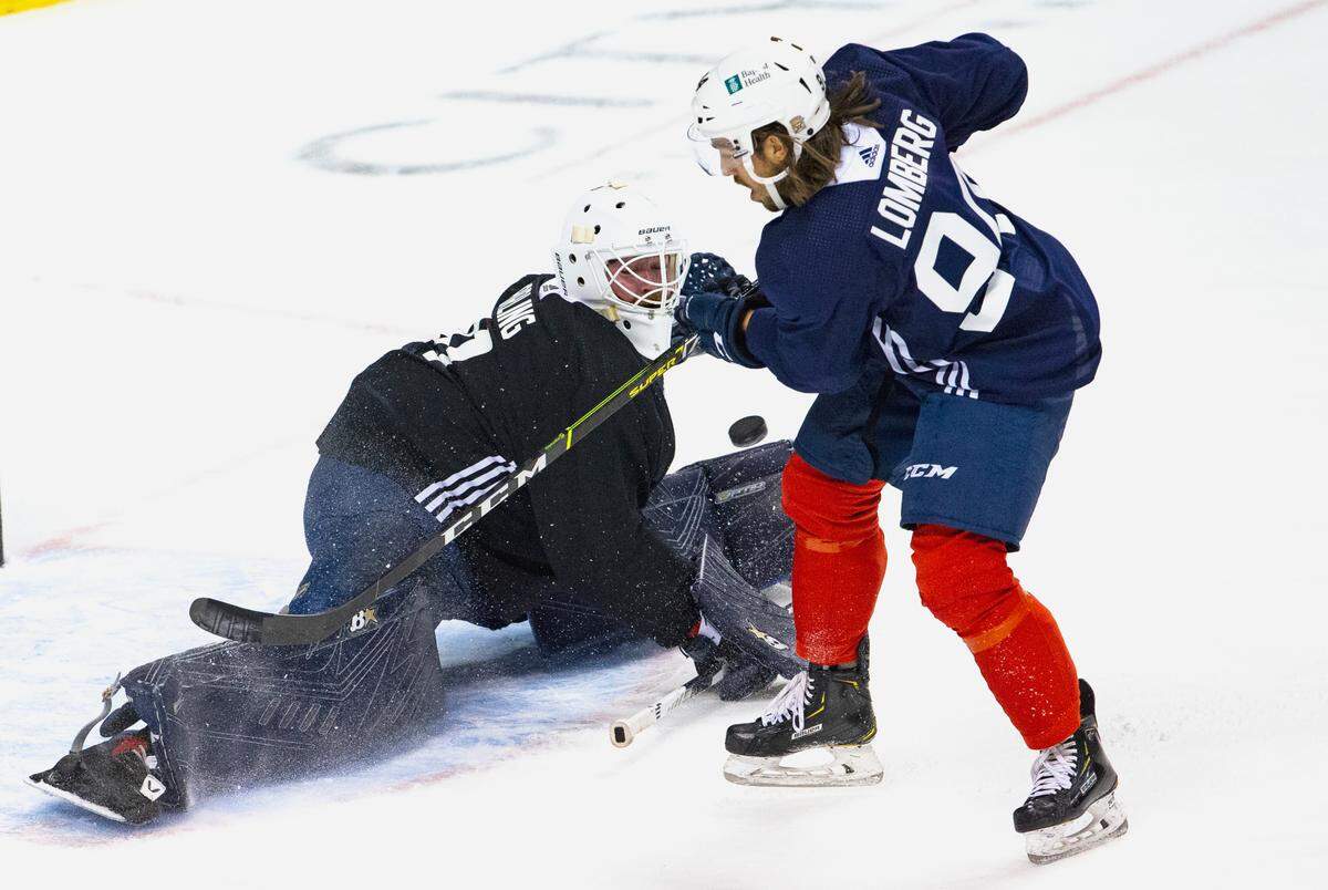 Florida Panthers goalie Scott Darling (31) blocks a shot by Florida Panthers left wing Ryan Lomberg (94) during the first practice of training camp in preparation for the 2020-21 NHL season at the BB&T Center on Monday, January 4, 2021 in Sunrise.