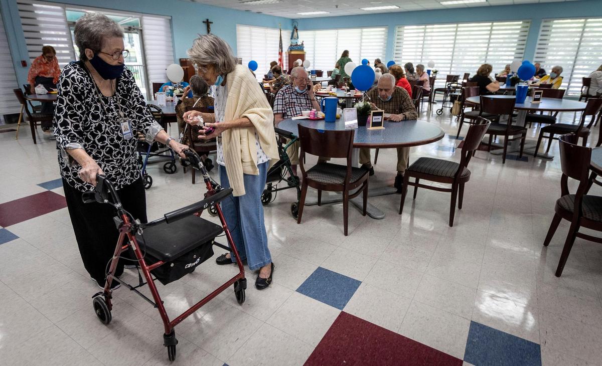 From left, Gregoria Reyes, 100, talks to Esther Ayllon, 88, in the dining room at Carroll Manor Senior Center in Miami on May 25, 2021. This is the first week of senior centers reopening their cafeterias. Many senior centers have not yet opened, but the Little Havana Activities and Nutrition Centers has reopened four, including Carroll Manor, and plans to open four more by June 14.