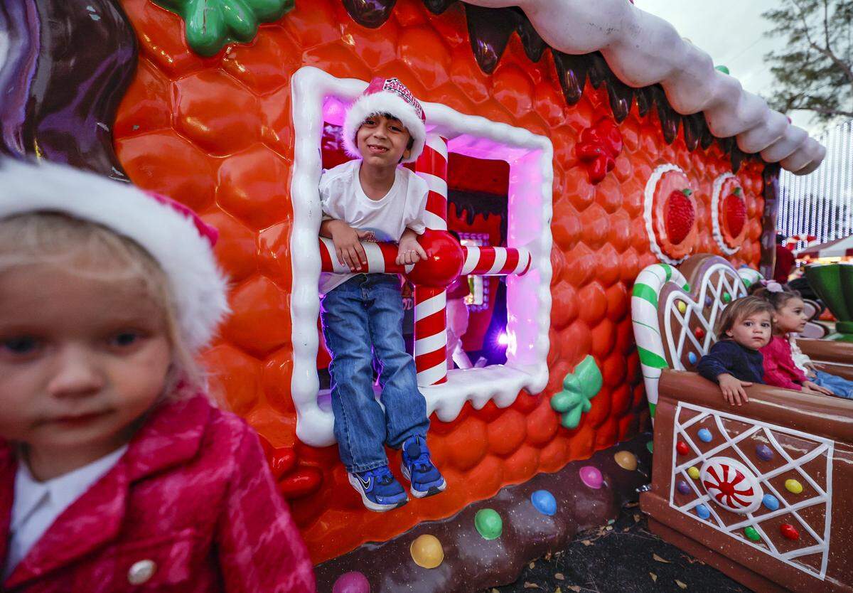 Enzo Semeraro, 5, and others play outside the Ginger Bread house at Christmas Wonderland at Tropical Park, a Miami-style holiday celebration of flavor and culture in Miami, Florida on Thursday, November 13, 2025.