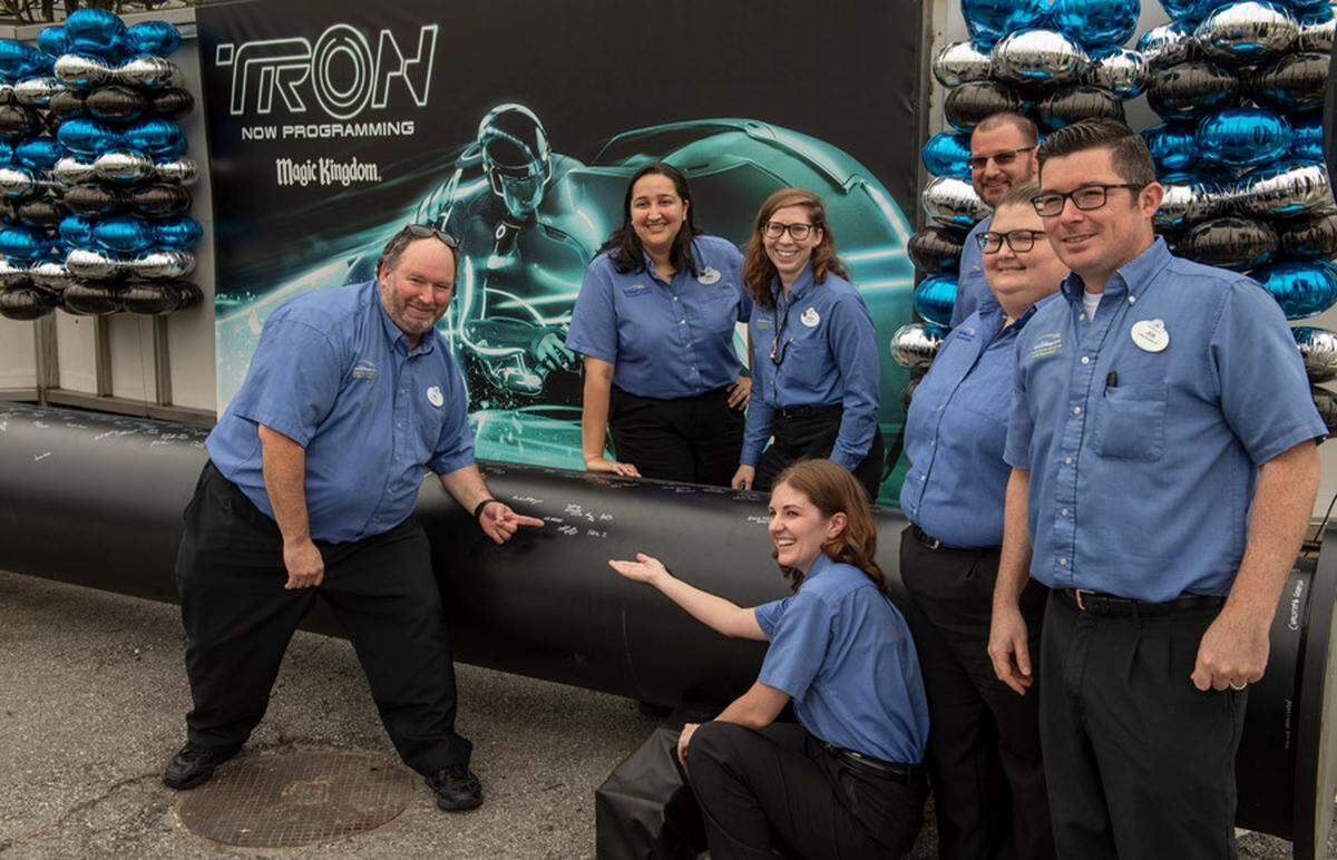 Disney cast members and project teams sign their names on one of the first steel support columns of the TRON roller coaster.