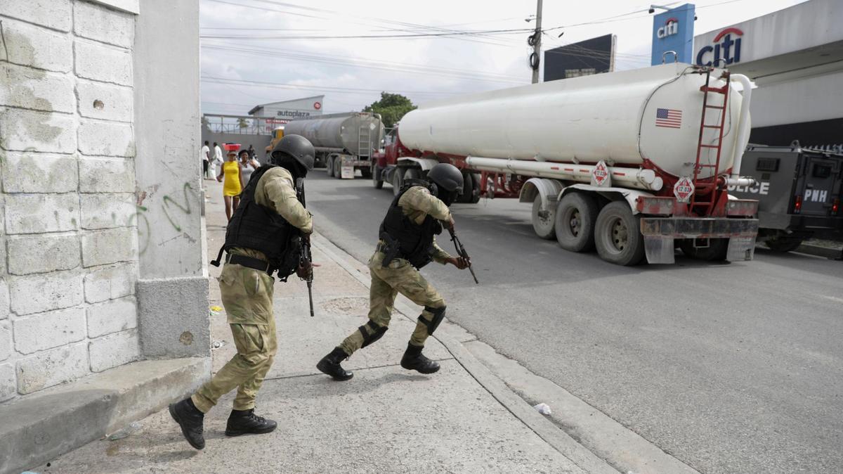 Police officers protect fuel trucks filled with gas as they drive from the Varreux fuel terminal, in Port-au-Prince, Haiti, Tuesday, Nov. 8, 2022. Trucks lined up at the fuel terminal to fill up their tanks for the first time since a powerful gang seized control of the area nearly two months earlier. Government officials said on Tuesday that gas stations, which have remained closed since mid-September, would be resupplied from Wednesday through Friday and would open to customers on Saturday.