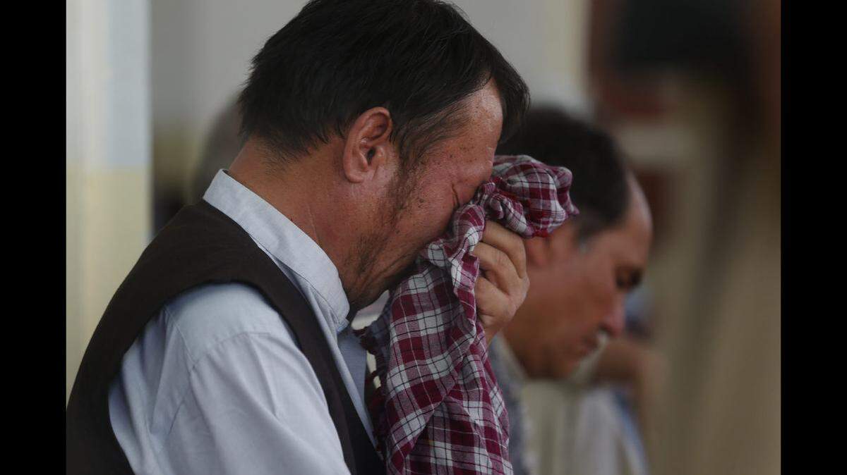 Guest weeps after a bombing at a wedding party in Kabul, Afghanistan, in which 80 people were killed. ISIS claimed responsibility.