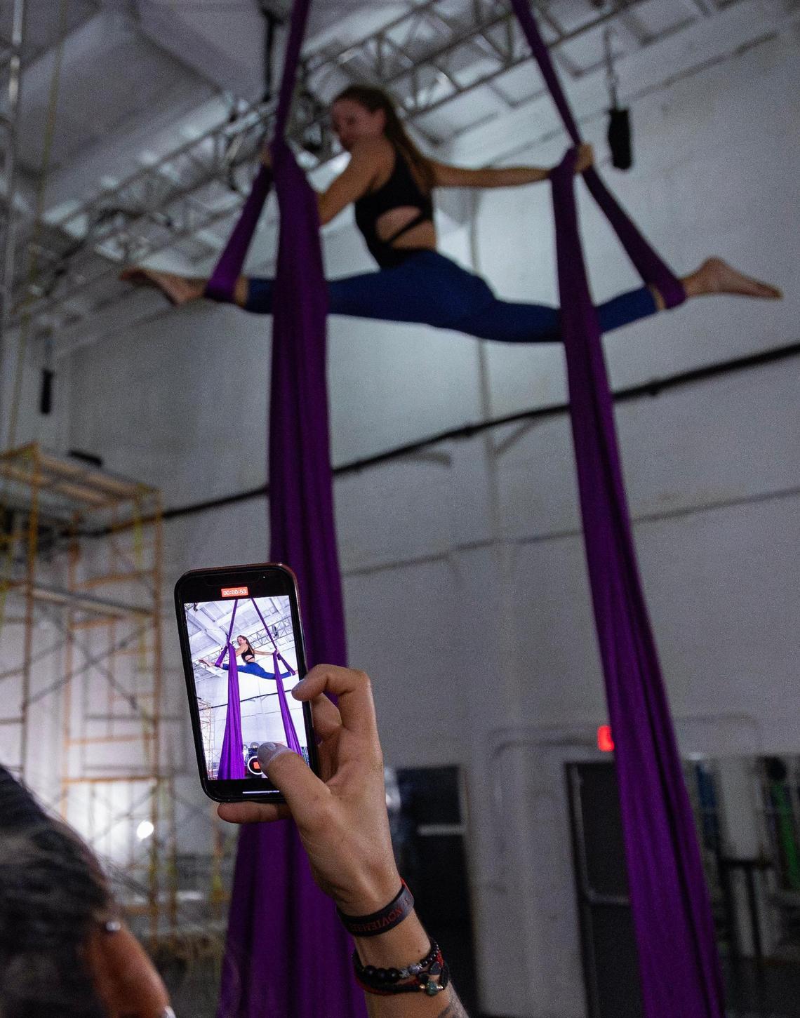 A student films Mila Puletti demonstrating a libra split at the Miami Circus Arts Center on July 12, 2023, in Miami, Fla. Students often record their instructors and themselves so they can look back and see what they need to practice.