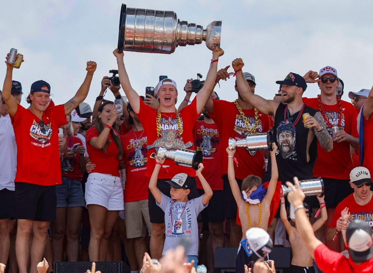 Florida Panthers center Anton Lundell hoists the Stanley Cup as teammates celebrate on stage during the team’s victory parade and rally along A1A in Fort Lauderdale, Florida, on Sunday, June 22, 2025