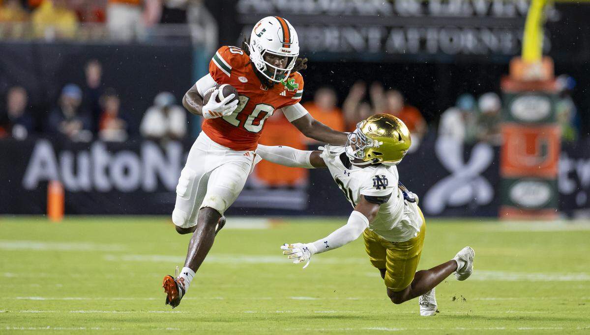 Miami Hurricanes wide receiver Malachi Toney (10) stiff arms Notre Dame Fighting Irish cornerback Karson Hobbs (21) in the first half of their NCAA football game at Hard Rock Stadium on Sunday, Aug. 31, 2025, in Miami Gardens, Fla.