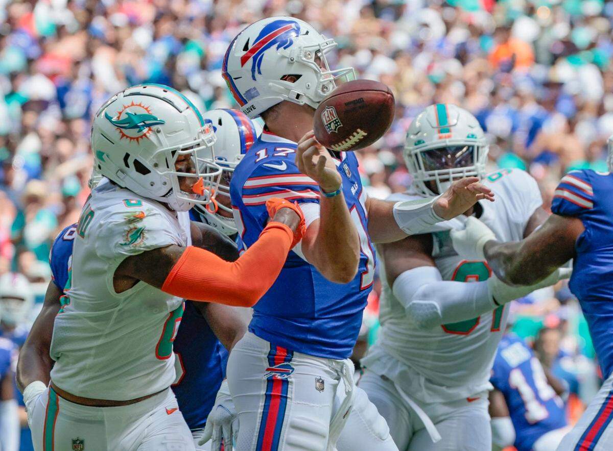 Buffalo Bills quarterback Josh Allen (17) loses the ball after getting hit by Miami Dolphins safety Jevon Holland (8) in the first quarter at Hard Rock Stadium in Miami Gardens on Sunday, September 25, 2022.