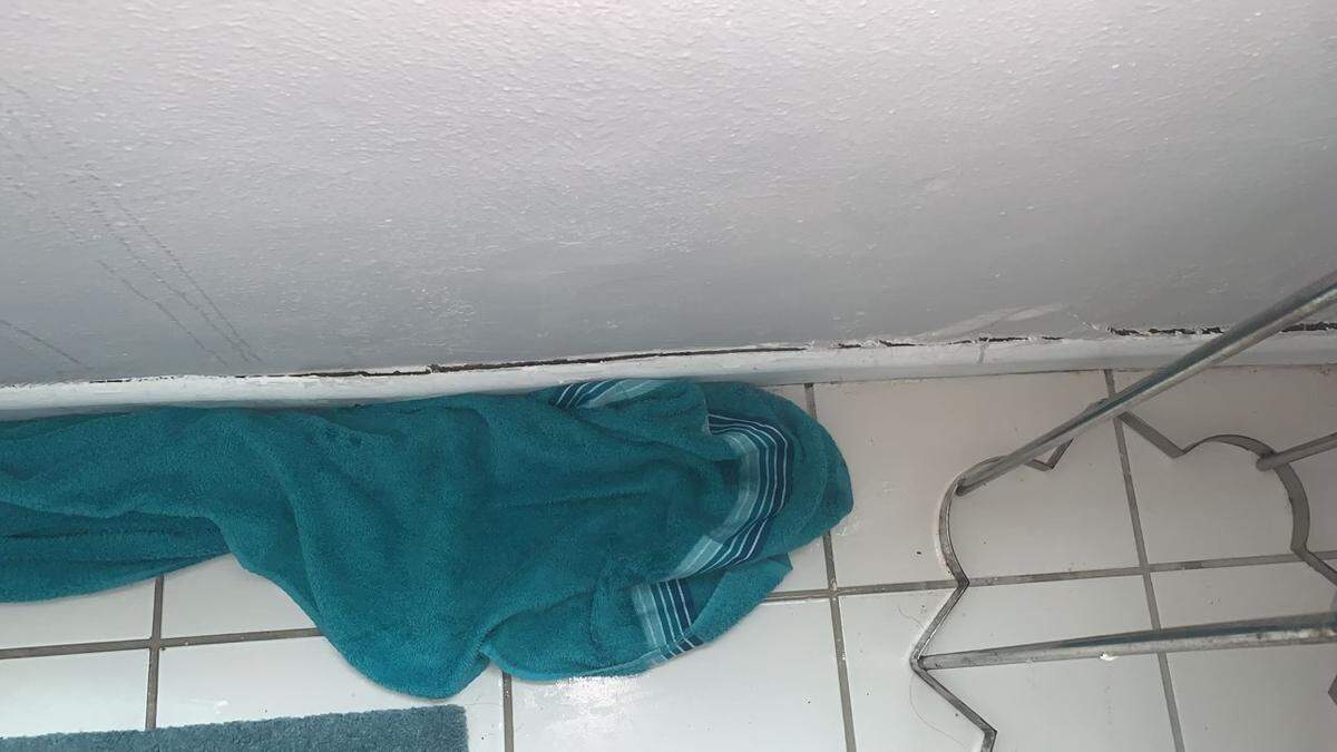 A towel is used to absorb water leaking down the wall of a unit inside the Mariner Place apartment building in the Middle Florida Keys city of Marathon.