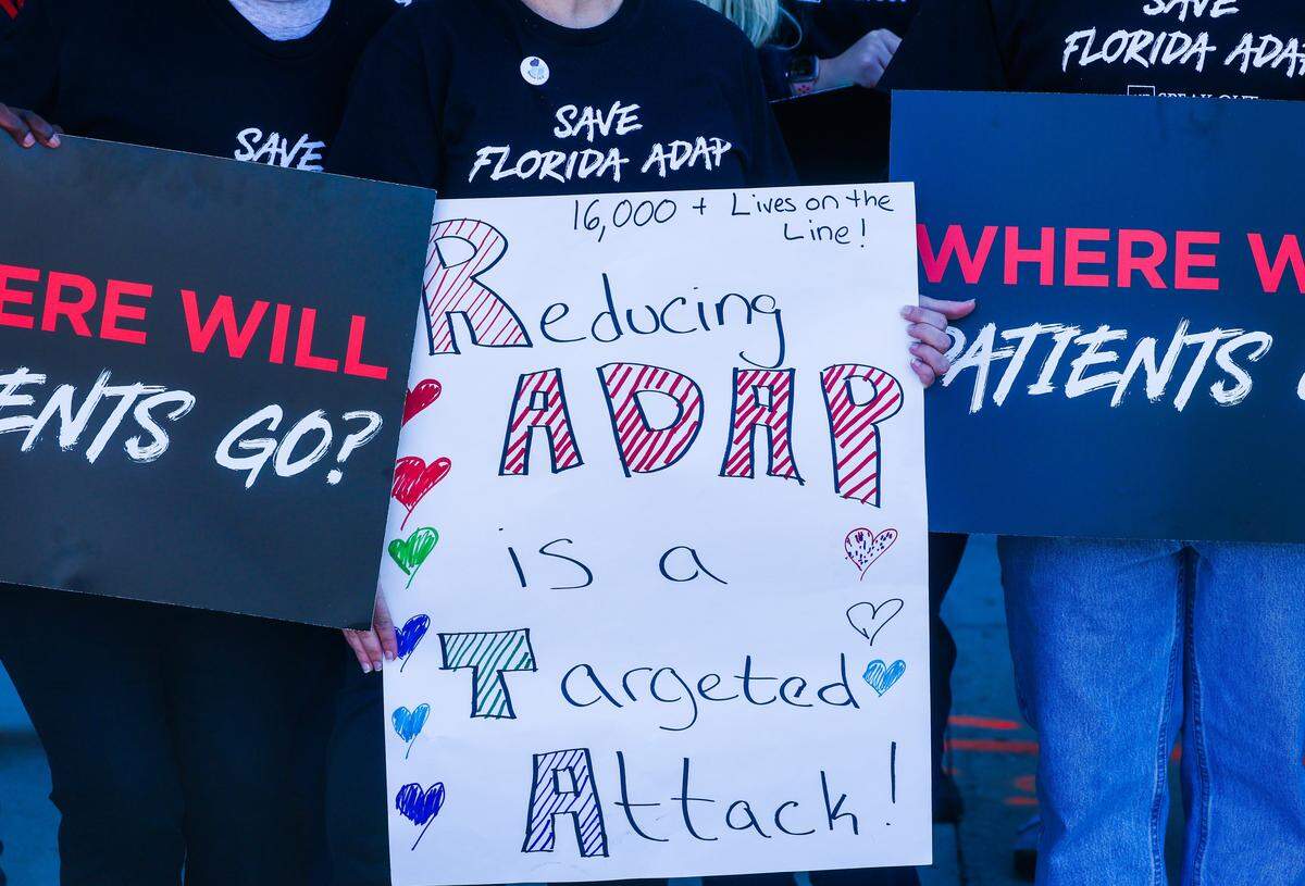 A sign reading “Reducing ADAP is a targeted attack” is displayed during a protest outside of the Pinellas County Florida Department of Health office on Friday, Jan. 30, 2026 in St. Petersburg. 