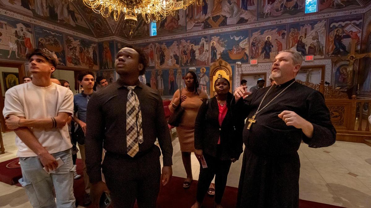 Darnel Charite, second from left, listens, along with other members of a St. Thomas University undergraduate class to Father Joseph Lucas, right, Pastor of Christ the Saviour Orthodox Cathedral as he describes the meaning of some of the iconography inside the cathedral.