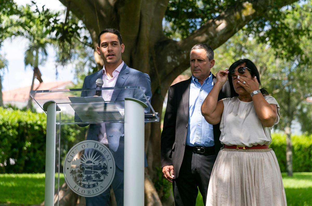 Martin Langesfeld, center, his father Pablo Langesfeld, and his mother, Andrea Langesfeld, participate in a ceremony for Martin’s late sister, Nicole “Nicky” Langesfeld, on Wednesday, June 22, 2022 in Doral, Florida.
