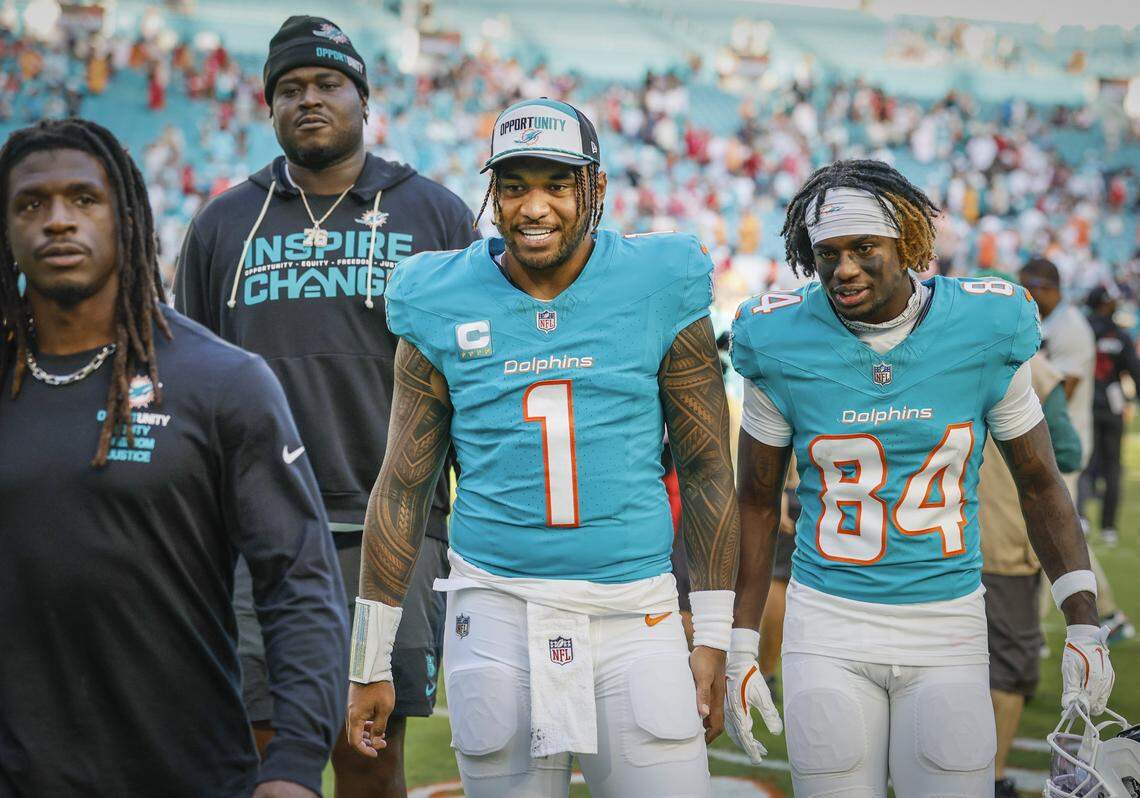 Miami Dolphins quarterback Tua Tagovailoa (1) walks of the field with wide receiver Tahj Washington (84) after the Dolphins defeat the Tampa Bay Buccaneers during the NFL football game at Hard Rock Stadium in Miami Gardens, Florida, on Sunday, December 28, 2025.
