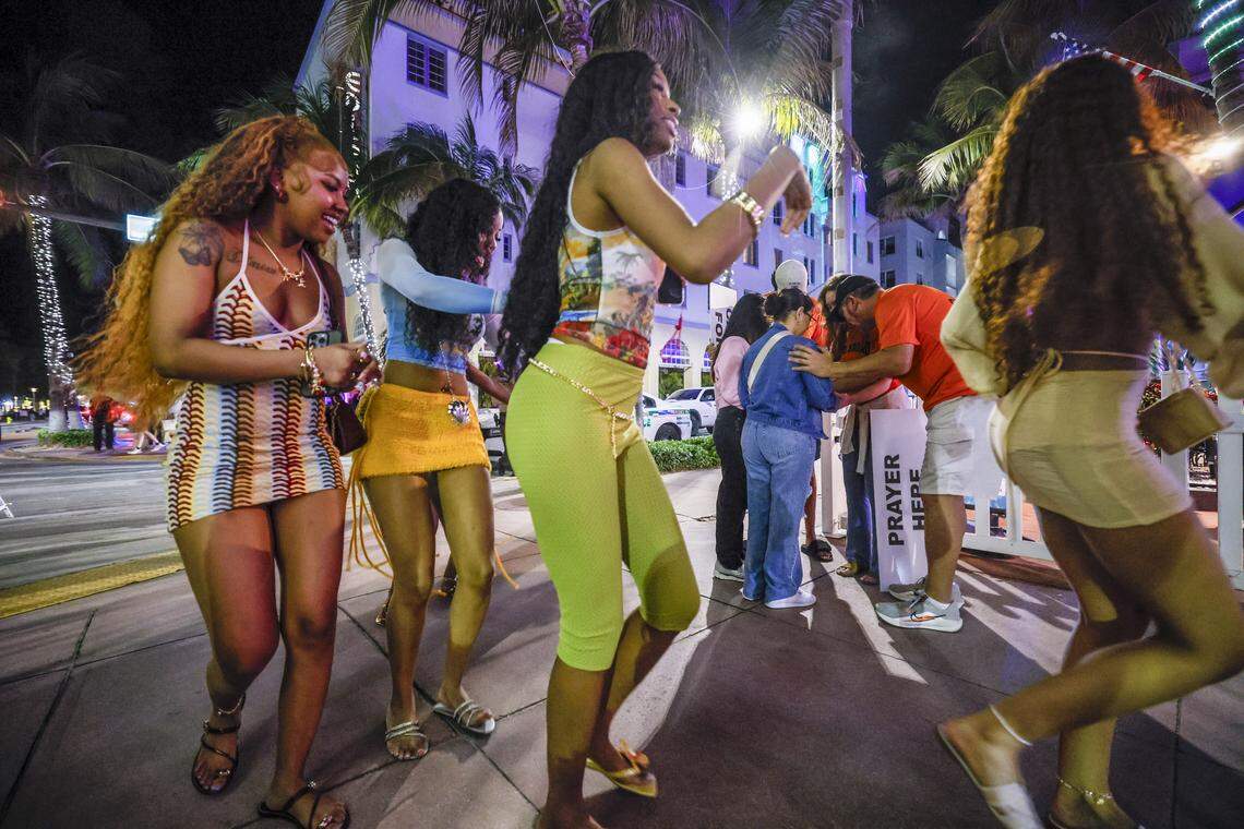 Women walk along Ocean Drive as a group prays with the God Squad, an interfaith prayer team of volunteers for the Miami Beach Police Department who serve as goodwill ambassadors during spring break, on Friday, March 20, 2026.