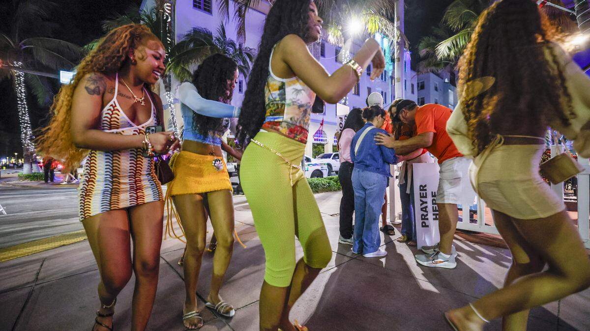 Women walk along Ocean Drive as a group prays with the God Squad, an interfaith prayer team of volunteers for the Miami Beach Police Department who serve as goodwill ambassadors during spring break in the South Beach neighborhood of Miami Beach Florida on Friday, March 20, 2026.