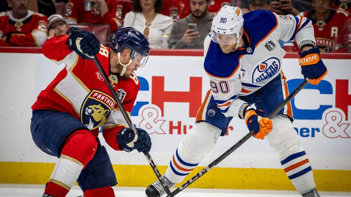 Edmonton Oilers right wing Corey Perry (90), right and Florida Panthers defenseman Nate Schmidt (88) fight for possession during the second period of Game 3 in the NHL Stanley Cup Final series at Amerant Bank Arena on Monday, June 9, 2025, in Sunrise, Fla.