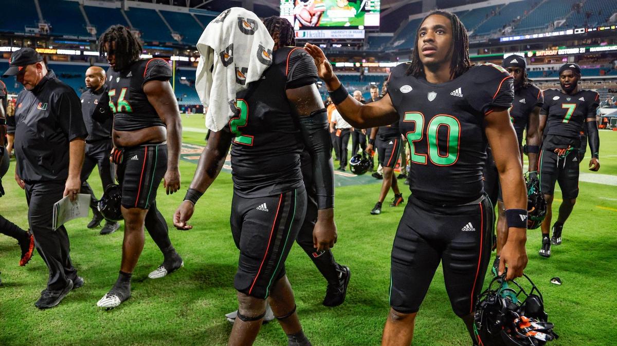 Miami Hurricanes running back Donald Chaney Jr. (2) wraps his head with a towel as he walks off the field with running back Terrell Walden II (20) after Georgia Tech Yellow Jackets defeat the Canes in the final seconds of the game at Hard Rock Stadium in Miami Gardens on Saturday, October 7, 2023.