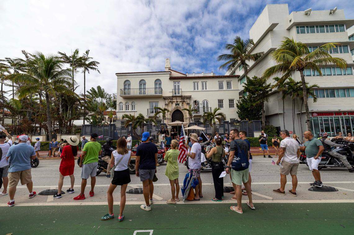 Spectators look on as parade participants march and drive past The Villa Casa Casuarina at the former Versace Mansion during the 16th Annual Veterans Day Parade off Ocean Drive on Monday, Nov. 11, 2024, in Miami Beach, Fla.