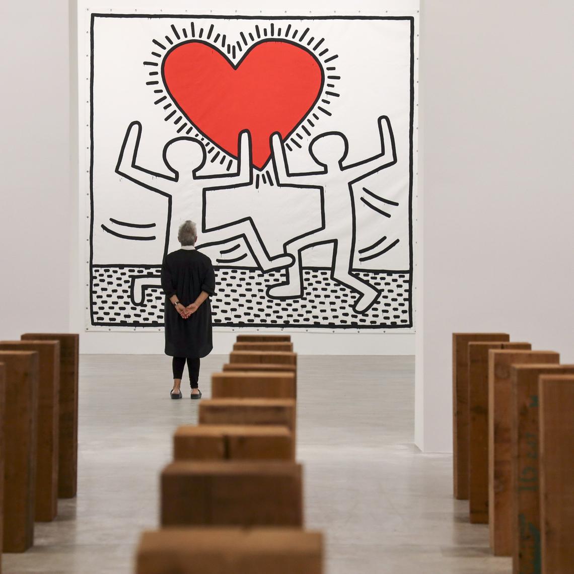 Art collector Mera Rubell looks up at Keith Haring’s “Untitled,” an acrylic on vinyl tarpaulin that she and husband Don acquired in 1982, as their new Rubell Museum in Miami’s Allapattah neighborhood prepares for its opening during Art Basel week. In the foreground is a 1979 installation by Carl Andre entitled “Llano Estacado.”