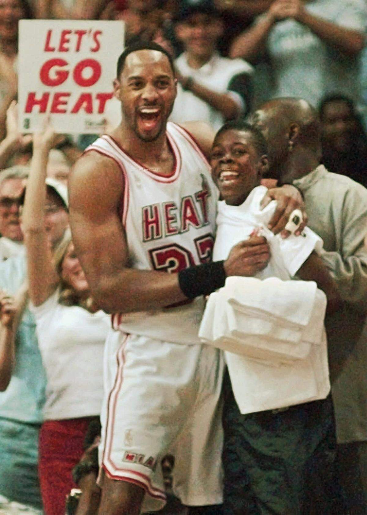 Miami Heat’s Alonzo Mourning is all smiles as he celebrates with one of the team attendants during Game 7 of their Eastern Conference semifinal in Miami Sunday, May 18, 1997. The Heat defeated the Knicks 101-90 to clinch the series. (AP Photo/Hans Deryk)