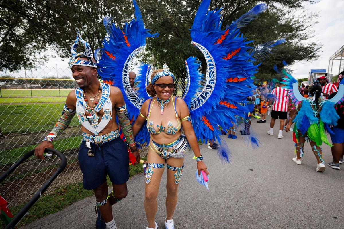 Andre Adams, left, and Fay Cottoy, who have attended Carnival for 40 years, smile as they walk in the Parade of Bands at Miami Carnival on Sunday, Oct. 13, 2024, at Miami-Dade County Fair Expo.