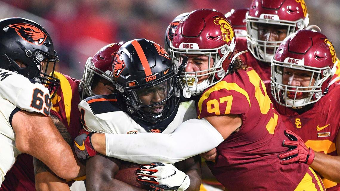 LOS ANGELES, CA - SEPTEMBER 25: Oregon State Beavers running back B.J. Baylor (4) is tackled by USC Trojans defensive lineman Jacob Lichtenstein (97) during a college football game between the Oregon State Beavers and the USC Trojans on September 25, 2021, at Los Angeles Memorial Coliseum in Los Angeles, CA. (Photo by Brian Rothmuller/Icon Sportswire) (Icon Sportswire via AP Images)