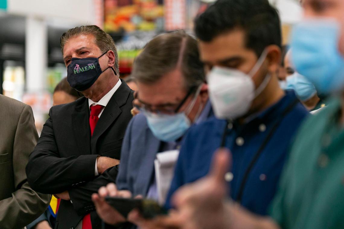 Hialeah Mayor Carlos Hernández listens as Gov. Ron DeSantis speaks during a press conference at a Navarro Discount Pharmacy in Hialeah, Florida, on Tuesday, Feb. 23, 2021. DeSantis announced that dozens of CVS Pharmacy y más and Navarro Discount Pharmacy stores will join the immunization effort.