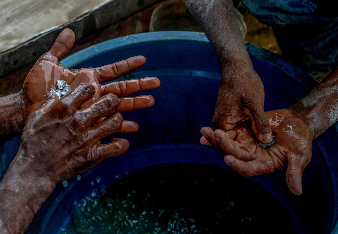 Men hold gold-mercury amalgam at a gold mine in El Callao in Venezuela’s Bolivar state. Although life in the mines of eastern Venezuela is hard and dangerous, tens of thousands from all over the country head for the mines daily in overcrowded trucks.