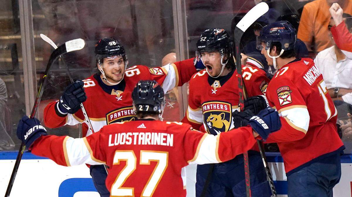 Florida Panthers defenseman MacKenzie Weegar (52) celebrates with Maxim Mamin (98), Eetu Luostarinen (27) and Mason Marchment (17) after scoring a goal during the third period of an NHL hockey game against the New York Rangers, Wednesday, Dec. 29, 2021, in Sunrise, Fla. The Panthers won 4-3. (AP Photo/Lynne Sladky)