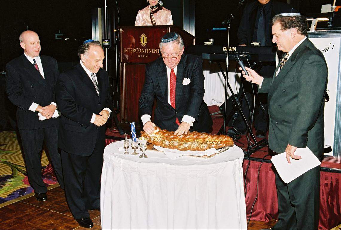 In this file photo from June 25, 2003, Harvey Chaplin, chairman and CEO of Southern Wine & Spirits, was honored by Temple Beth Sholom in Miami Beach as the temple’s Humanitarian of the Year. Chaplin breaks bread in a blessing ceremony with, from left, Rabbi Robert Davis, Rabbi Gary Glickstein and Cantor Steven Haas.