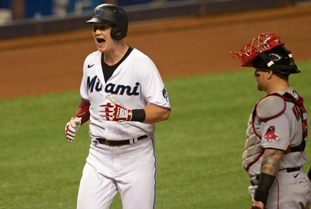 Boston Red Sox catcher Christian Vázquez (7) looks on as Miami Marlins first baseman Garrett Cooper (26) reacts after hitting a two run home run during the first inning of a baseball game at at Marlins Park in Miami on Wednesday, September 16, 2020.