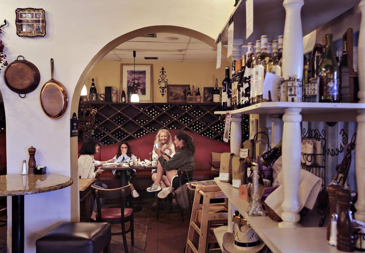 Three generations of self-described “storm chasers,” Margie Mannion, left, and granddaughter, Claire Luce, 12, and daughter, Margaret Luce, right, and a friend, Marcia Wolf, pass time inside Paris in Town French Café in North Palm Beach on Monday, September 2, 2019 as Hurricane Dorian crawls toward Florida while the Category 4 storm continues to ravage the Bahamas.