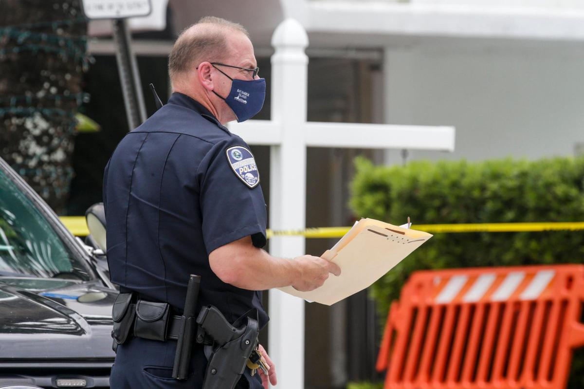 A Bay Harbor Islands police officer holds a folder with documents outside the Forum building at 1080 93rd Street on Thursday, Sept. 2, 2021, after town officials deemed the building to be unsafe.